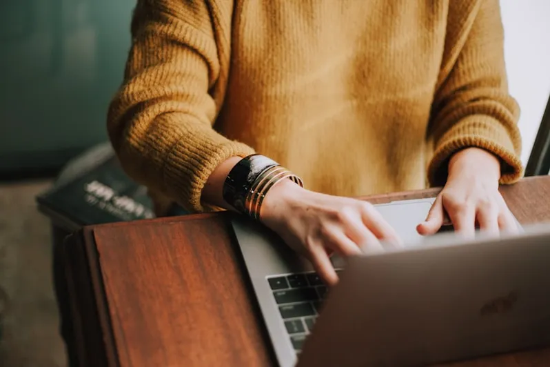  A person working on a laptop at a desk, highlighting focus and individual growth in a professional setting.